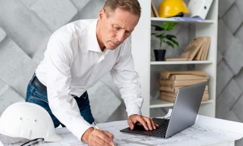 notyfikacje w systemie ERP - inżynier produkcji sprawdza powiadomienia na laptopie